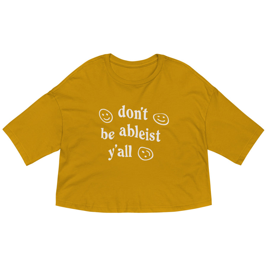mustard yellow crop tee with drop shoulder, and "don't be ableist y'all" printed on the front in white with smiley faces